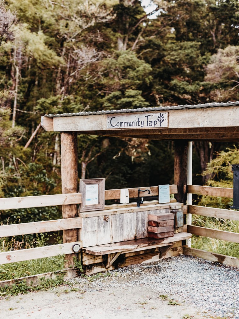 The Community Tap structure on Duck Creek Road, a covered timber stand with a tap over a wooden bench